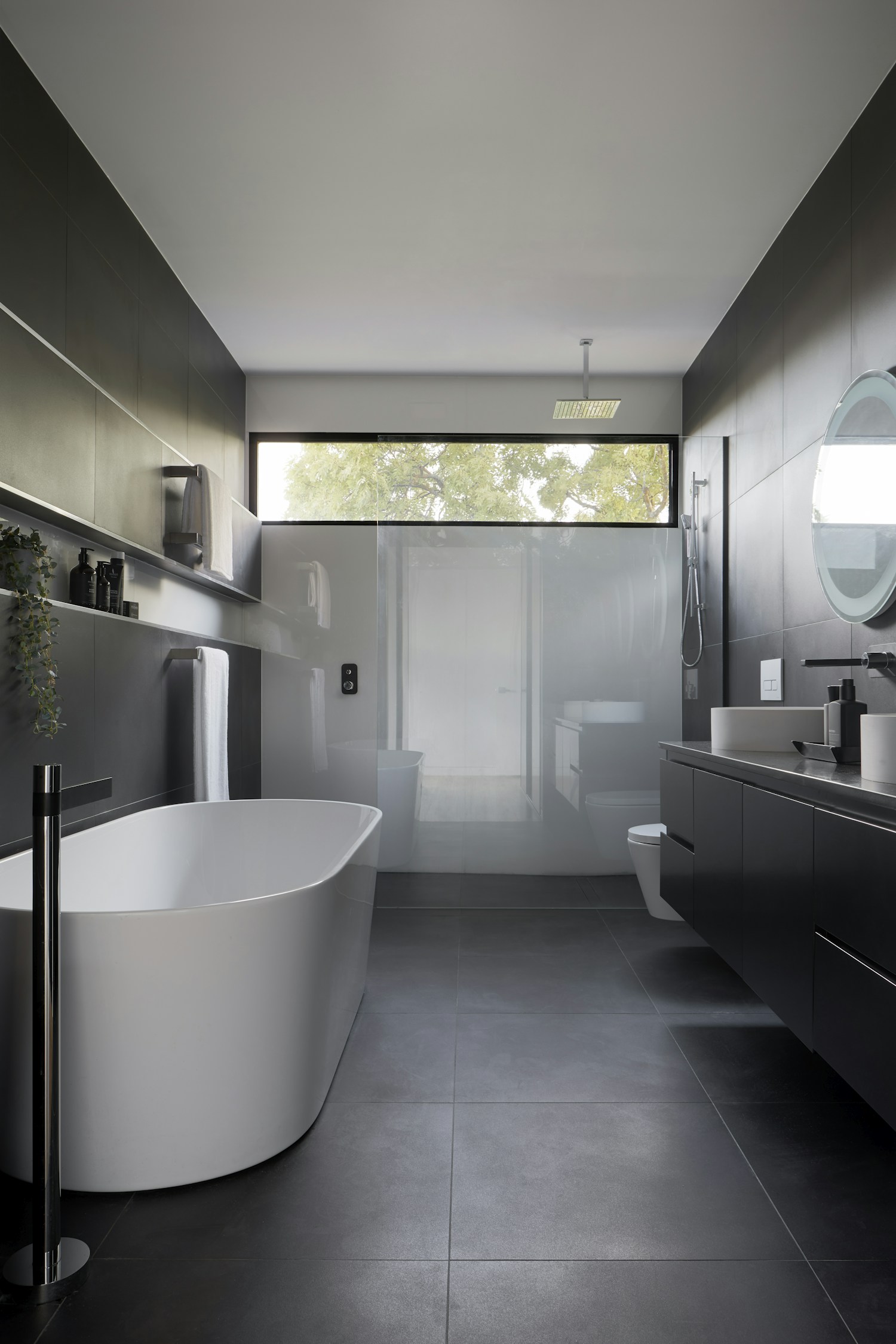 Salle de bain épurée avec niches de rangement et linge plié